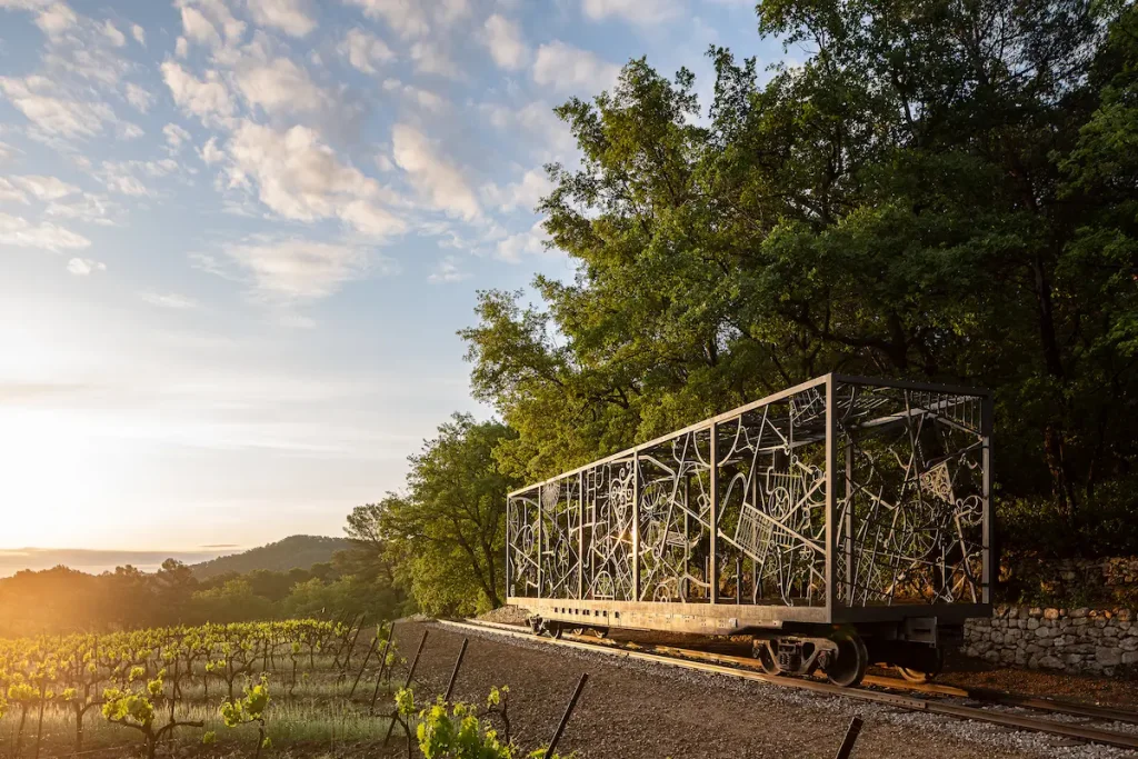 Bob Dylan's Rail Car, a wrought-iron sculpture built into a freight wagon on its own length of track, at sunrise above the vines at Chateau La Coste