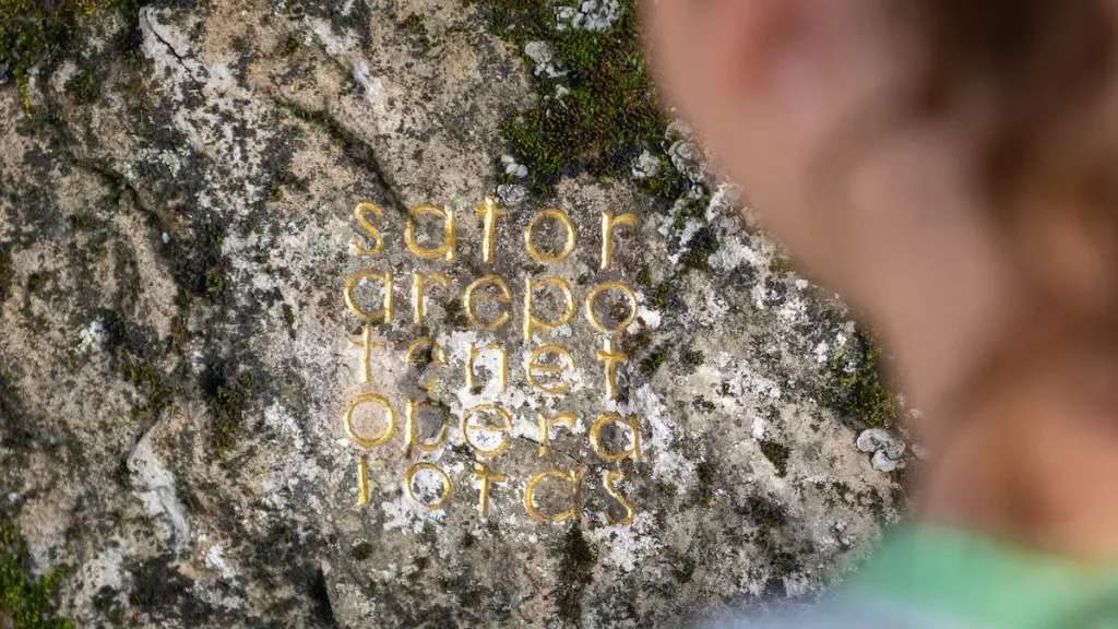 herman de vries's sator arepo tenet opera rotas, a Latin palindrome in gold leaf carved into a lichen-covered rock in the mountains above Digne-les-Bains
